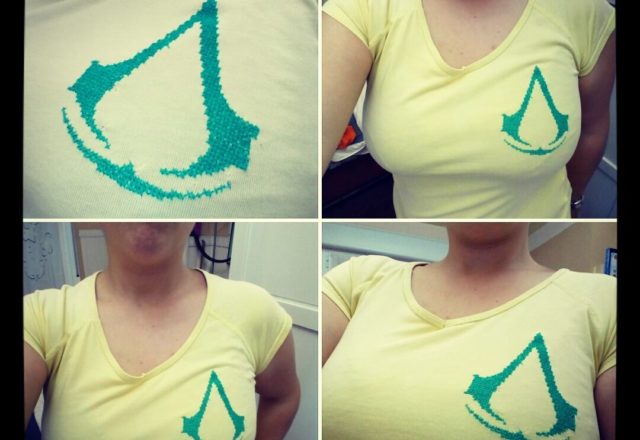 Logo Assassin’ s Creed punto croce sulla t-shirt autrice Fan su Facebook Lluvisa Heredia Alvarez-Laviada